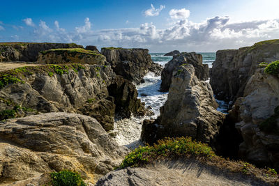 Panoramic view of rocks and sea against sky