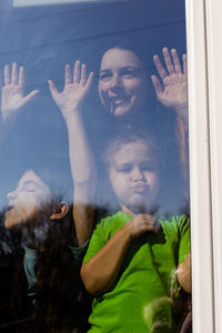 Portrait of happy girl looking through window