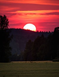 Scenic view of silhouette field against sky during sunset