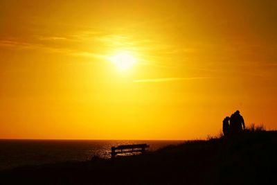 Silhouette of boat in sea at sunset