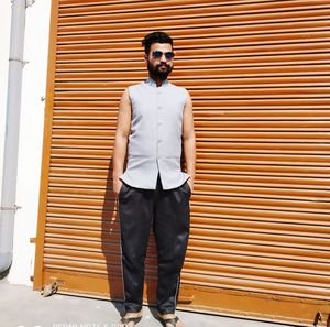 Portrait of young man standing against wall