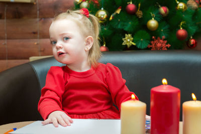 Portrait of cute girl playing with christmas decoration