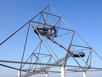 Low angle view of crane against clear blue sky