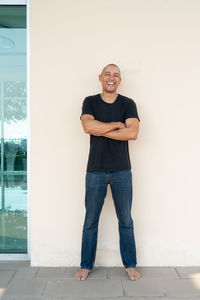 Portrait of young man standing against wall