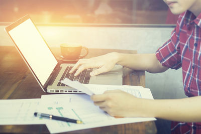 Close-up of hand using laptop on table