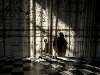 Silhouette people standing on tiled floor