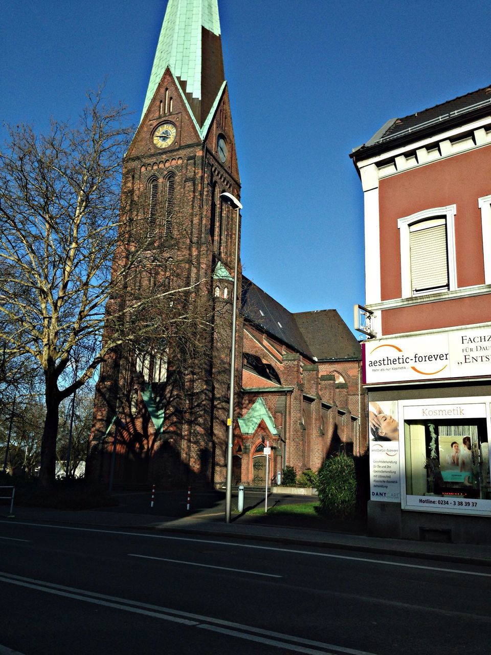 building exterior, architecture, built structure, clear sky, blue, religion, church, place of worship, street, spirituality, house, sky, low angle view, road, tree, outdoors, city, day, residential structure