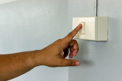 Cropped hand of man pressing switch button