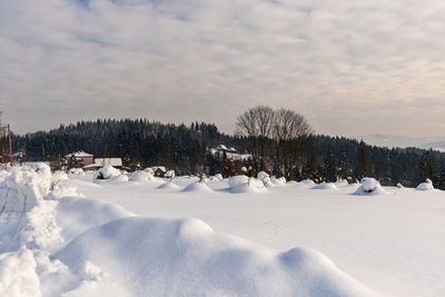 Snow covered field against sky