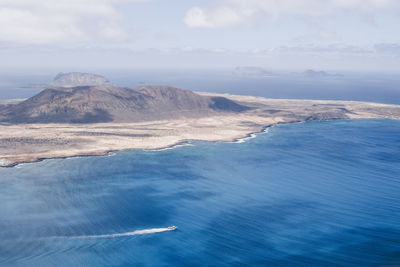 Scenic view of sea and mountains against sky