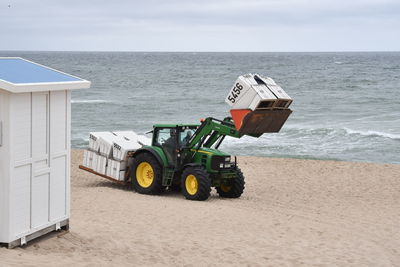 Deck chairs on beach against sky