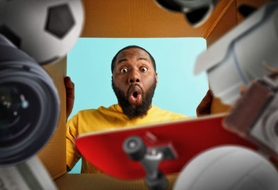 Low angle portrait of shocked man peeking in box