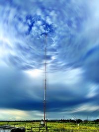 Low angle view of electricity pylon on field against sky