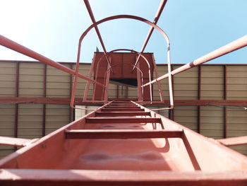 Directly below shot of ladder against sky on sunny day