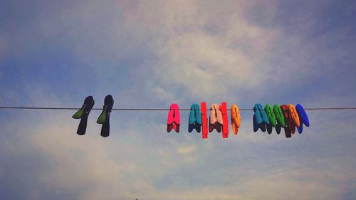 Low angle view of hanging lights against clear blue sky