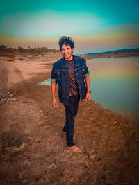 Portrait of young man standing by river