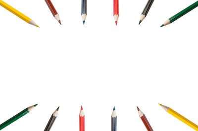 High angle view of colored pencils against white background