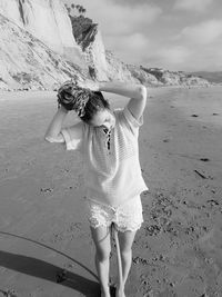 Woman tying hair at beach