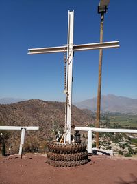 Cross on mountain against clear blue sky