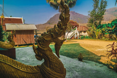 Statue by trees against sky
