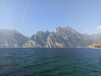 Scenic view of sea and mountains against blue sky