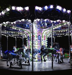 People at amusement park ride at night