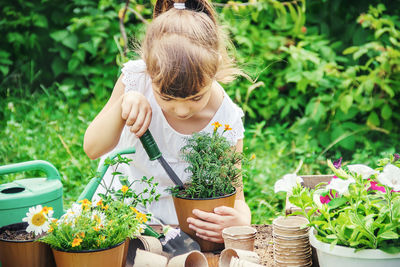 Portrait of young woman gardening in yard