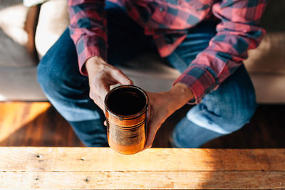 Low section of man sitting on table