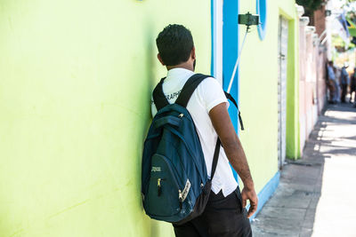 Rear view of man standing against wall