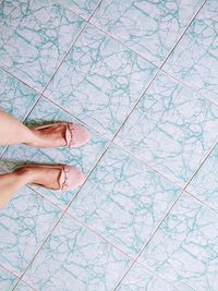 Low section of woman standing on tiled floor