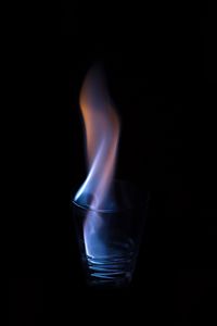 Close-up of illuminated light bulb against black background