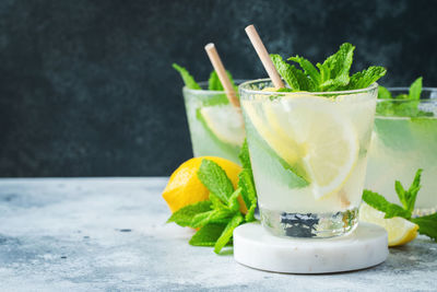 Two glass with lemonade or mojito cocktail with lemon and mint, cold refreshing drink.