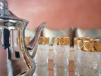 Close-up of glasses by jar on table