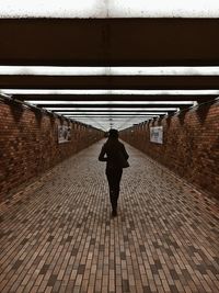 Full length rear view of man walking in subway