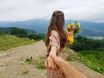 Man holding woman hand in nature