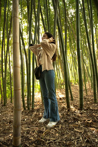 Rear view of woman standing in forest