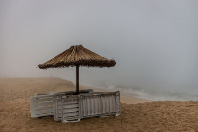 Lifeguard hut on beach against sky