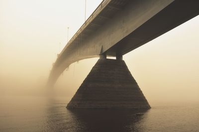 Iron bridge on stone supports  on a foggy morning at dawn 