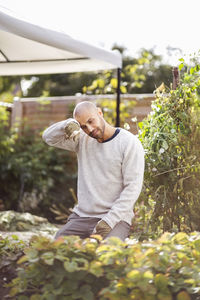Man wiping sweat form forehead while gardening at yard