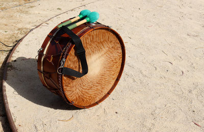 Close-up of a wooden drum and beaters on the sand. music concept photography.