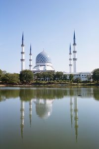 Reflection of temple in building against sky