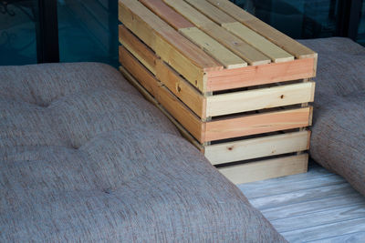 Close-up of wooden crate amidst mattresses