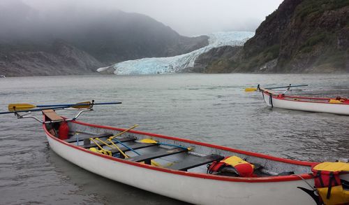 Boat moored on lake against mountains