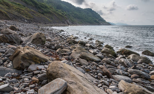 Rocks on beach against sky