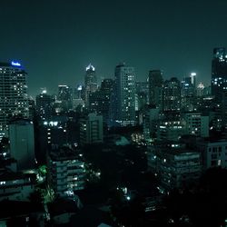 Illuminated buildings in city against sky at night