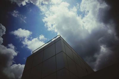Low angle view of modern building against cloudy sky