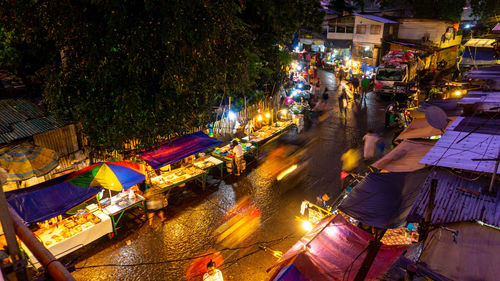 Illuminated street market in city at night