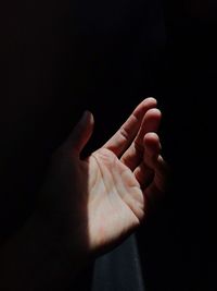 Cropped image of person hand against black background