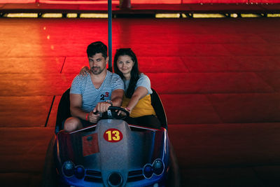 High angle view of couple driving toy car