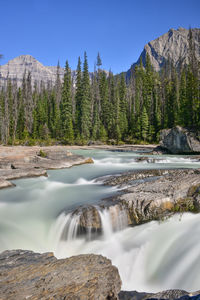 Scenic view of waterfall against sky